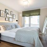 Schlafzimmer mit Doppelbett, Wandbildern und Fenster mit Blick.