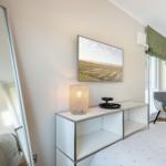 Schlafzimmer mit Bett, Schrank, Fernseher und Stuhl