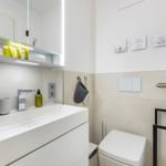 Moderne Badezimmer mit Waschbecken, Spiegel und Toilette.