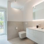 Badezimmer mit Toilette, Waschbecken und Fenster zur Außenseite.
