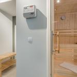 Sauna mit Holzbank und Thermostat an der Wand
