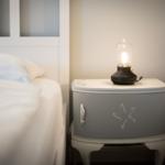 Schlafzimmer mit Bett und Nachttisch mit Lampe