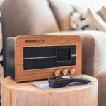 Holztablett mit Radio und Fernbedienung vor Sofa