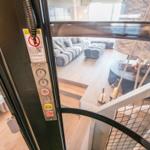 Lift mit Tastenfeld zeigt Blick auf Wohnbereich mit Sofa und Kamin.