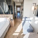 Schlafzimmer mit Bett, Sofa und Duschbereich.