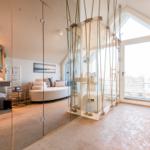 Duschbereich mit Seilkonstruktion, Badewanne und großes Fenster mit Blick.
