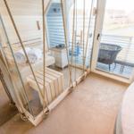 Sauna mit Glaswand und Außenterrasse mit Sitzgelegenheit.