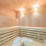 Sauna mit Holzbank und weißen Handtüchern