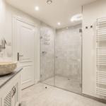 Badezimmer mit Dusche, Waschtisch und Heizkörper