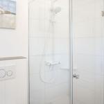 Dusche mit Glaswand und Wandbild an der Wand