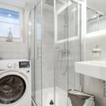 Bathroom with shower, washing machine, and sink