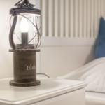 Lamp on nightstand next to bed with pillow