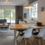 Wohn- und Essbereich mit Sofa, Esstisch und Fenster zur Terrasse.