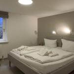 Schlafzimmer mit Bett, Fenster und Stuhl