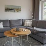 Graue Eckcouch mit Kissen und Tisch im Wohnzimmer.