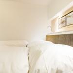 Double bed with white bedding and woven headboard