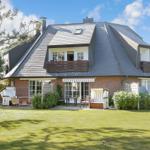House with garden, terrace, and beach chairs. Roof with slate and wooden balcony.