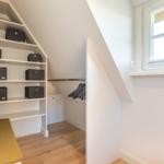 Schlafzimmer mit Dachschrägen, Kleiderschrank und Fenster.