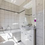 Badezimmer mit Badewanne, Waschbecken und Heizung.