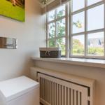 Bathroom with window, basket, and wall picture
