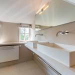 Bathroom with two sinks, mirrors, and windows