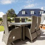 Terrasse mit Esstisch und Stühlen, Strandkorb und Haus im Hintergrund.