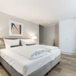 Schlafzimmer mit Doppelbett, Nachttischen und Kleiderschrank.