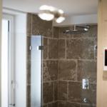 Dusche mit Glaswand und Steinwand im Badezimmer