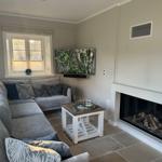 Wohnzimmer mit Sofa, Fernseher und Kamin