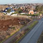 Straße mit Blick auf Häuser und Heideflächen