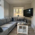 Graue Sofa-Ecke, Fernseher und Kamin im Wohnzimmer.