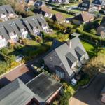 Luftbild von mehreren Häusern mit Gärten und Straßen in einer Wohngegend.