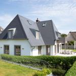 Modern villa with dormers and garden area with terrace.