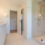 Bathroom with shower, sink, and heater.