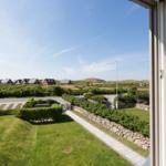 From the window, you can see a well-kept garden with stone path and holiday homes in the background.