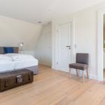 Bedroom with double bed, wardrobe, and bathroom with shower.