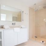 Bathroom with shower, sink, and mirrors