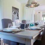 Dining table with chairs and tableware in dining area