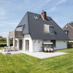 Modern villa with terrace, garden, and sun loungers.