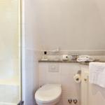 Badezimmer mit Dusche, Toilette und Waschbecken mit Handtuch