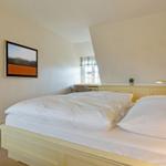 Schlafzimmer mit Doppelbett, Wandbild und Fenster mit Blick.