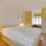 Schlafzimmer mit Doppelbett, Nachttisch und Fenster