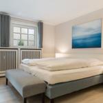 Bedroom with bed, nightstand, and windows.
