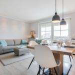 Living and dining area with sofa, dining table, and windows.
