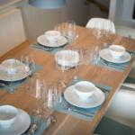 Dining table set for six with modern furnishings.