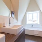 Badezimmer mit Waschbecken, Badewanne und Fenster