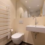 Badezimmer mit Toilette, Waschbecken und Heizkörper.