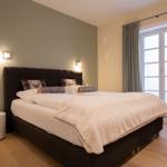 Schlafzimmer mit Bett, Fenster und Nachttisch