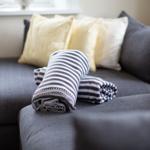 Grafe Sofa mit Kissen und gefalteten Decken