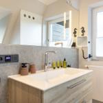 Badezimmer mit Waschtisch, Spiegel und Fenster